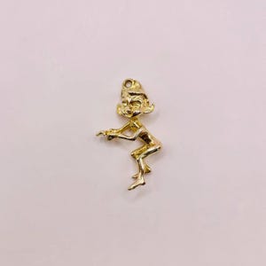 May include: A gold-toned charm of a sitting elf with a pointed hat and a mischievous expression.