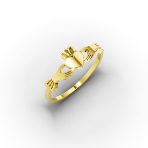 May include: A gold Claddagh ring. The ring's design includes a heart, crown, and two hands. The heart is centrally placed, crowned, and clasped by hands on either side. The ring is set against a white backdrop.