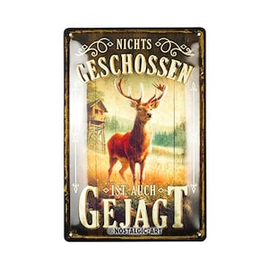 Puede incluir: Un letrero de metal de estilo vintage con fondo marrón y detalles dorados. El letrero presenta un ciervo con cuernos y el texto "Nichts Geschossen Ist Auch Gejagt" y "Nostalgic-Art".