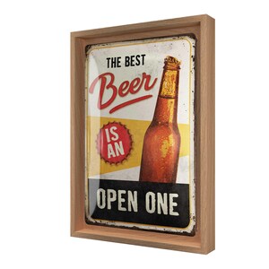 Könnte beinhalten: Ein gerahmtes Schild im Vintage-Stil mit dem Text "THE BEST Beer IS AN OPEN ONE". Das Schild zeigt eine braune Bierflasche und einen rot-gelben Hintergrund. Der Rahmen besteht aus hellbraunem Holz.