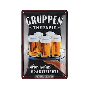 May include: A black and red metal sign with the text "Gruppen Therapie" and an illustration of a hand holding a tray with four glasses of beer. The text "...hier wird praktiziert!" is below the tray and the text "©NOSTALGIC-ART" is at the bottom of the sign.