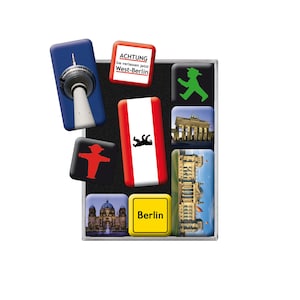 Könnte beinhalten: Ein Set aus neun Kühlschrankmagneten mit Bildern von Berlin, Deutschland. Die Magnete zeigen das Brandenburger Tor, das Reichstagsgebäude, die Berliner Mauer und den Berliner Fernsehturm. Die Magnete sind alle rechteckig und haben einen schwarzen Hintergrund. Der Text "ACHTUNG Sie verlassen jetzt West-Berlin" befindet sich auf einem der Magnete.
