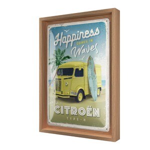 Könnte beinhalten: Gerahmtes Metallschild im Vintage-Stil mit einem gelben Citroën Typ H-Van am Strand mit einem Surfbrett. Das Schild zeigt "Happiness comes in Waves" und "Citroën". Der Rahmen besteht aus hellbraunem Holz.
