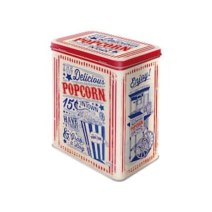 May include: A rectangular popcorn tin with a red lid and cream-coloured body. The tin features red and blue stripes, text reading "The Most Delicious Popcorn In Town", and an illustration of a popcorn cart. The tin has a vintage design.