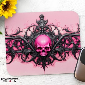 Peut inclure: Crâne rose avec un motif orné noir sur un fond rose. Le crâne est entouré de volutes noires et d'une couronne noire. Il s'agit d'un tapis de souris.