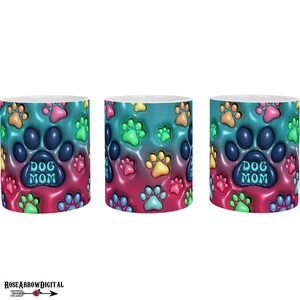 May include: A white ceramic mug with a colorful design of paw prints and the text "Dog Mom". The paw prints are in shades of blue, green, yellow, orange, and pink.