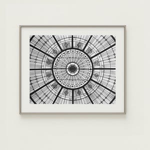 May include: Black and white photograph of a circular stained glass window with a geometric pattern.