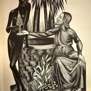 May include: A white ceramic mug with a black handle and the text "But First, Coffee" in a black, bold font. The mug is on a white surface. The mug is approximately 10 cm tall.