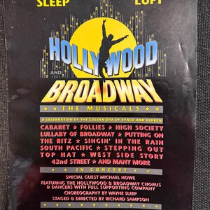 Peut inclure: Programme souvenir du concert musical "Hollywood and Broadway". Avec Wayne Sleep et Lorna Luft. Le programme liste des comédies musicales comme Cabaret, Follies et West Side Story. L'image a un fond noir avec du texte jaune et bleu.