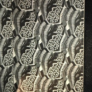 May include: Monochrome artwork with a repeating pattern of figures and foliage. The design is a detailed linocut or woodcut style, with high contrast between the black and white elements. The artwork is likely a print.