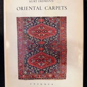 May include: A book titled "Oriental Carpets" by Kurt Erdmann. The cover features a detailed image of a red, blue, and cream-colored oriental rug. The publisher's name, Zwemmer, is at the bottom.