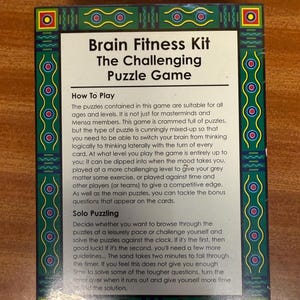Puede incluir: Una caja verde y amarilla con el texto "Brain Fitness Kit The Challenging Puzzle Game" en la parte delantera. La caja incluye instrucciones sobre cómo jugar al juego, incluyendo el juego en solitario y el juego contra reloj.