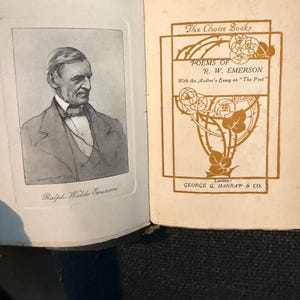 May include: Open book with a black and white portrait of Ralph Waldo Emerson on the left page. The right page features the title "POEMS OF R. W. EMERSON" in brown lettering, with floral design elements and the publisher's name.