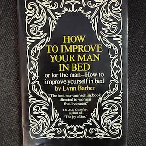 Op de afbeelding: Een boek met een zwarte kaft en de titel "HOW TO IMPROVE YOUR MAN IN BED" in het geel. De kaft heeft een witte decoratieve rand. De auteur is Lynn Barber. Het boek wordt beschreven als een seksuele voorlichtingsboek.