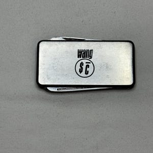 May include: A silver money clip with a built-in pocket knife. The clip has the text "Wang $C" engraved on it.