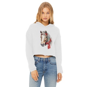 May include: White cropped hoodie with long sleeves featuring a watercolour illustration of a brown horse wearing a red scarf.