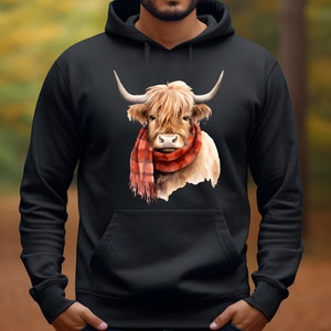 May include: Black hoodie with a graphic of a Highland cow wearing a red and black plaid scarf. The cow is looking directly at the viewer.