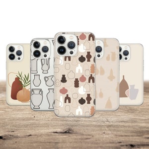 May include: Five phone cases with abstract designs. The cases feature various patterns, including line drawings of vases, and abstract shapes in neutral tones of beige, brown, and white. The cases are displayed on a wooden surface.