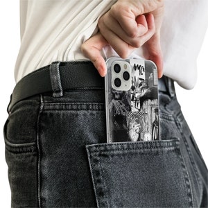 May include: A black and white phone case with a graphic design featuring a heart, a target, and other abstract shapes. The case is in a back pocket of a pair of dark gray jeans.