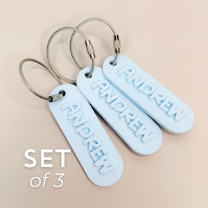 Conjunto de 3 pingentes personalizados para mochila escolar, incluindo etiqueta com nome, pingente decorativo para lancheira e lembrancinha escolar. Ideal para presentear crianças na volta às aulas.