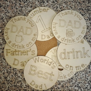 May include: A set of six round wooden coasters with laser-engraved designs. The coasters feature various messages related to Father's Day, including "Thank you Dad have a drink on me", "World's Best Dad", and "Father's Day".