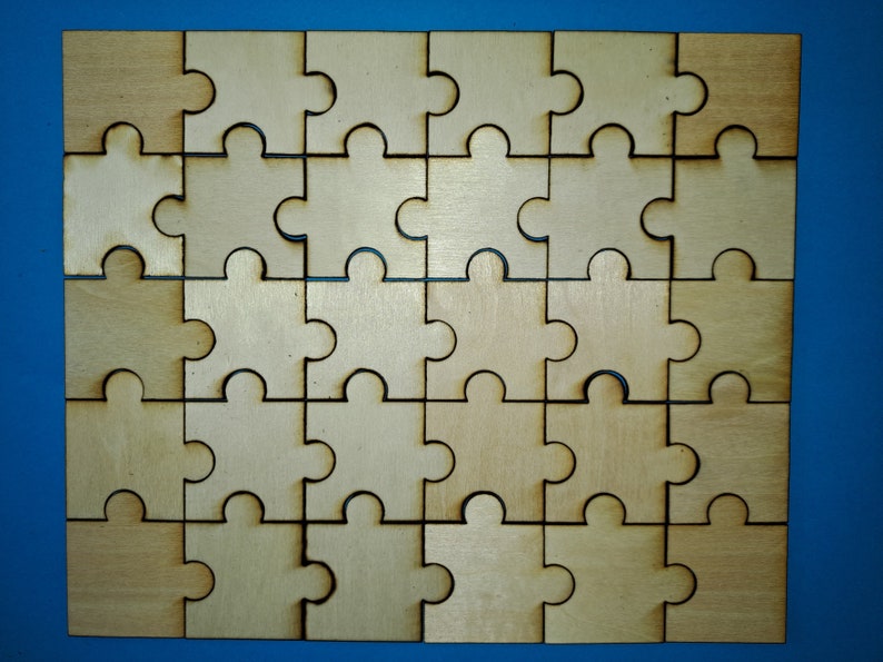 May include: A wooden jigsaw puzzle with 25 pieces, all in the shape of a puzzle piece. The pieces are arranged in a 5x5 grid, and the puzzle is complete. The puzzle is made of light brown wood and has a natural finish.
