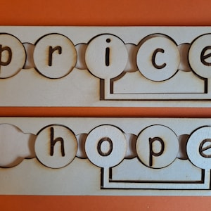 May include: Two wooden boards with cut-out circles that spell out the words "price" and "hope".