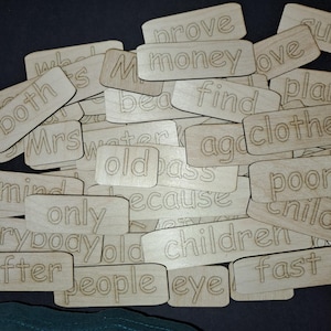 May include: A set of wooden tiles with various words written on them, including "prove", "money", "both", "find", "old", "children", "people", "eye", "fast", and more. The tiles are arranged in a random order.