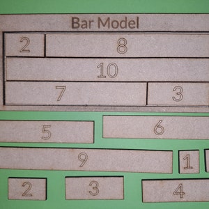 Könnte beinhalten: Ein Barmodell-Mathe-Puzzle mit den Zahlen 2, 3, 4, 5, 6, 7, 8, 9, 10 und 11, die auf rechteckigen Holzstücken geschrieben sind. Die Stücke sind in einem Gittermuster angeordnet, wobei die Zahlen 2, 8, 10, 7 und 3 in der oberen Reihe und die Zahlen 5, 6, 9, 1 und 1 in der unteren Reihe stehen.