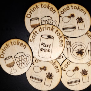 Könnte beinhalten: Acht Holzmarker mit verschiedenen Bildern und Texten. Die Marker sind rund und haben eine braune Holzmaserung. Der Text auf den Markern lautet "Drink token", "Food token", "Soft drink token" und "Fizzy drink".