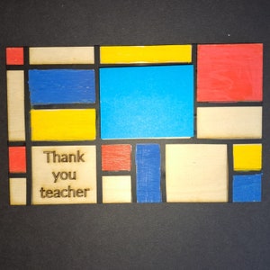 May include: Wooden plaque with a Mondrian-inspired design, featuring blue, yellow, and red painted blocks. The words "Thank you teacher" are laser-etched into a light-coloured square.