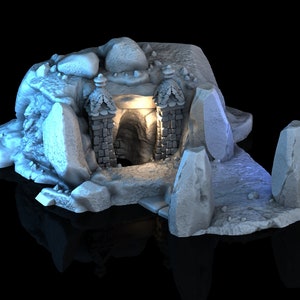 May include: A white, 3D printed miniature of a cave entrance with a stone archway and a glowing light inside. The cave is surrounded by rocks and boulders.