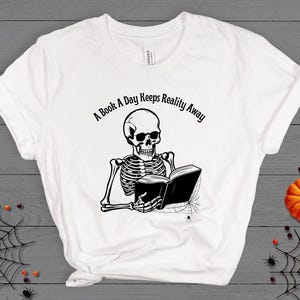A Book A Day Keeps Reality Away Skeleton Fall Reading Shirt, Halloween Skeleton Book Tees