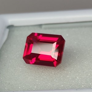 Peut inclure: Une pierre précieuse rouge foncé de taille émeraude rectangulaire.