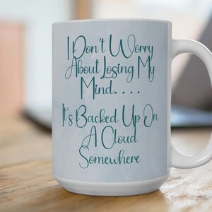May include: White ceramic coffee mug with a teal blue design that reads "I Don't Worry About Losing My Mind.... It's Backed Up On A Cloud Somewhere".