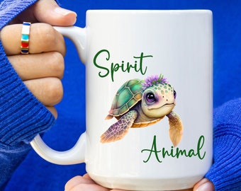 May include: White ceramic mug with a green turtle with a purple flower crown and the text "Spirit Animal" in green.