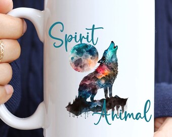May include: White ceramic coffee mug with a watercolor design of a wolf howling at the moon. The text "Spirit Animal" is printed on the mug in teal blue.