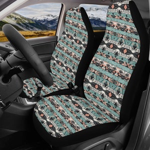 May include: A pair of car seat covers with a geometric pattern in shades of teal, black, white, and pink. The pattern features abstract shapes and lines.