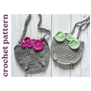 May include: Two gray crocheted bags with adjustable straps. One bag has a pink flower design and the other has a green flower design.