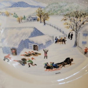 Puede incluir: Un plato de cer&aacute;mica vintage con una escena de invierno. El plato presenta un paisaje nevado con una granja, &aacute;rboles y personas. La escena est&aacute; pintada en un estilo caprichoso con colores brillantes. El plato est&aacute; firmado "Moses".