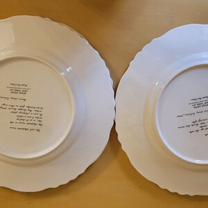 Puede incluir: Dos platos de cena de cer&aacute;mica blanca con bordes festoneados. La parte posterior de cada plato tiene una inscripci&oacute;n negra con el texto "The Collectors' Choice, Made in England, Royal Doulton, Fine Bone China, Designed by Susan Williams, Hand Painted, Dishwasher Safe, Microwave Safe, Oven Safe, Made in England, Royal Doulton, Fine Bone China, Designed by Susan Williams, Hand Painted, Dishwasher Safe, Microwave Safe, Oven Safe".