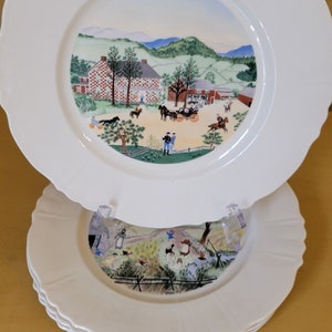 Puede incluir: Un juego de tres platos de cer&aacute;mica blanca con bordes festoneados. Cada plato presenta una escena pintada colorida de una granja rural con un campo verde y un cielo azul.