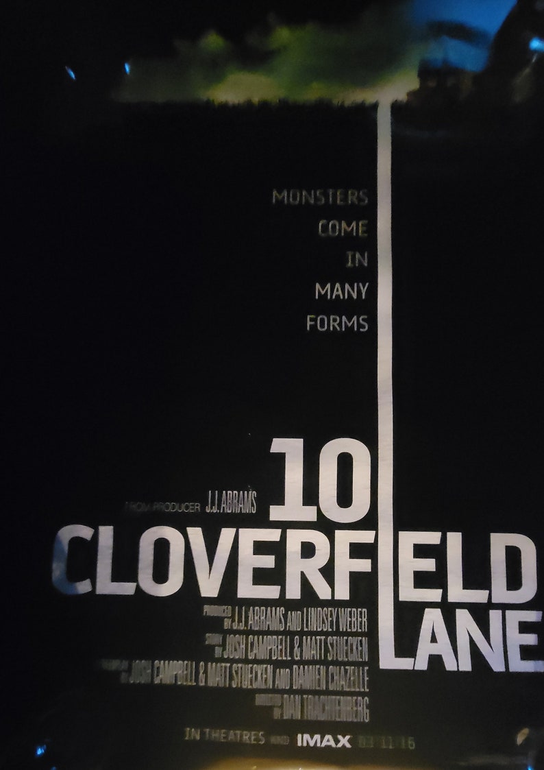 Puede incluir: Un p&oacute;ster de pel&iacute;cula para la pel&iacute;cula "10 Cloverfield Lane" con el t&iacute;tulo en texto blanco sobre fondo negro. El p&oacute;ster tambi&eacute;n presenta el texto "Los monstruos vienen en muchas formas" y "Del productor J.J. Abrams".