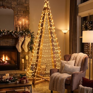 Puede incluir: Una estructura de marco de madera alta y triangular diseñada como un árbol navideño, envuelta en múltiples hileras de luces de cadena de color blanco cálido. El marco consta de varios listones de madera verticales unidos en la parte superior, creando una silueta cónica.