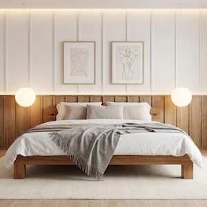 May include: A modern bedroom with a wooden bed frame, white bedding, and a gray throw blanket. Two framed line art prints hang above the bed. The room features a light-colored rug, wooden headboard, and two spherical pendant lights.
