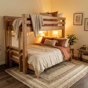Puede incluir: Una litera de madera con acabado marrón claro. La litera superior tiene una manta y almohadas de color óxido, mientras que la litera inferior tiene un edredón beige y almohadas de color óxido. Una alfombra tejida está en el suelo.