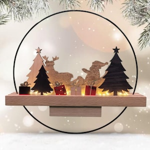 Könnte beinhalten: Weihnachtsdekoration aus Holz mit einer Silhouette von Santa Claus in einem Schlitten, der von einem Rentier gezogen wird, mit Weihnachtsbäumen und Geschenken. Die Szene ist in einem schwarzen Kreisrahmen angeordnet und mit kleinen Lichtern beleuchtet.