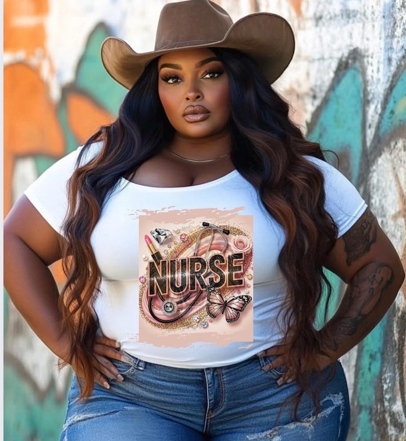 Puede incluir: Camiseta blanca con un dise&ntilde;o gr&aacute;fico que presenta un estetoscopio, l&aacute;piz labial, diamantes y una mariposa. El gr&aacute;fico tambi&eacute;n incluye la palabra "NURSE" en letras doradas con purpurina.