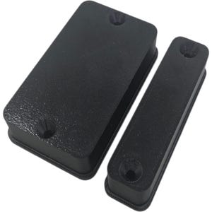 May include: Two black rectangular plastic components with textured surfaces. One is a larger rectangle, and the other is a smaller, more elongated rectangle. Each has a circular indentation on one side, likely for mounting or attachment.