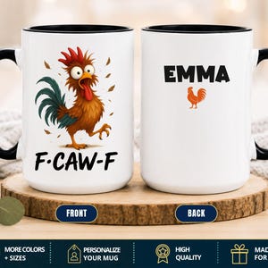 May include: A white ceramic mug with a black handle and rim. The front features a cartoon rooster with wide eyes and the text F-CAW-F. The back displays the name EMMA in black capital letters above a small orange rooster silhouette graphic.